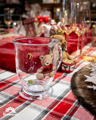 Tasse avec ours en peluche sur table de Noël au style rustique et chaleureux.